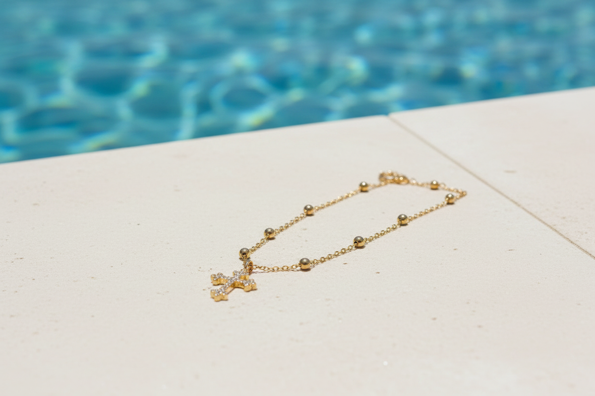 Cross pendant necklace on a pool ledge