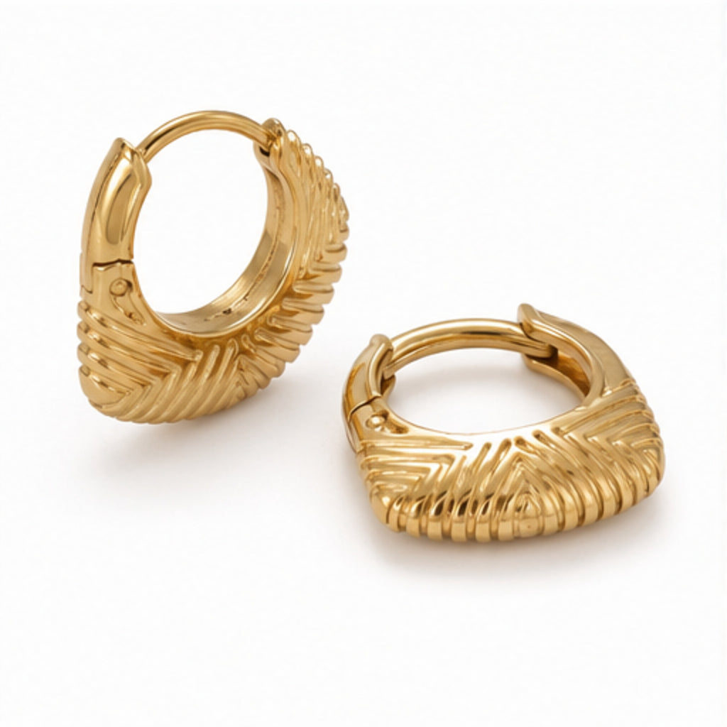 A pair of gold huggie hoop earrings with a textured, ribbed chevron pattern, displayed on a clean white background.