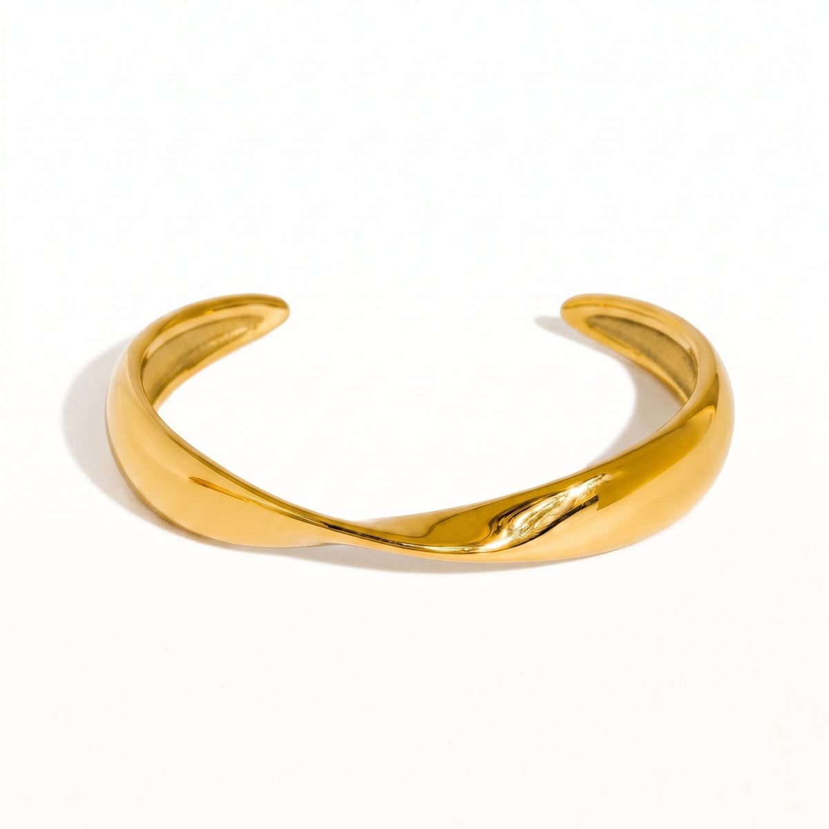 twisted gold bangle bracelet on white background