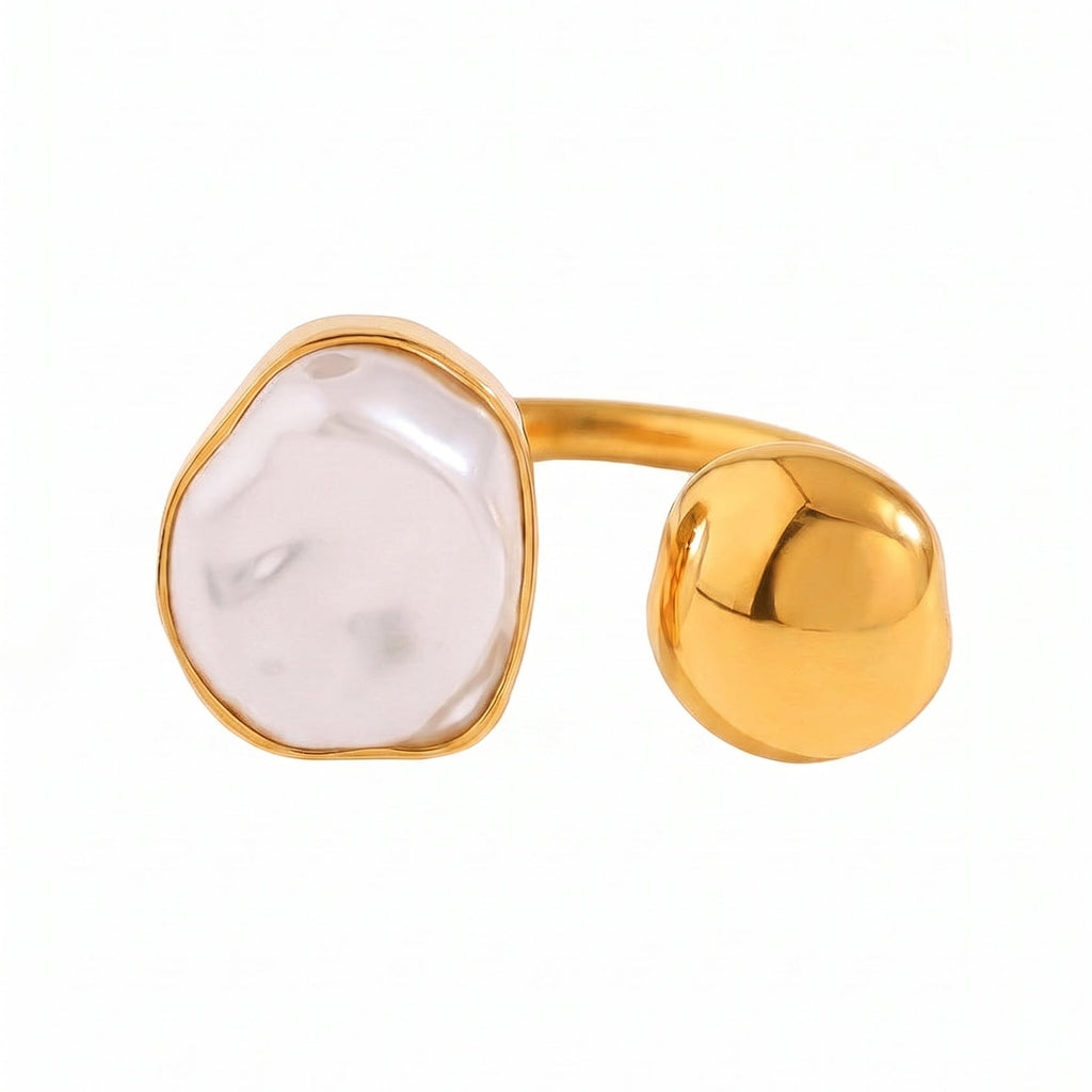 A gold-plated ring featuring a large, irregularly shaped pale pinkish-white stone on one end and a polished, rounded gold ball on the other, set against a plain white background.