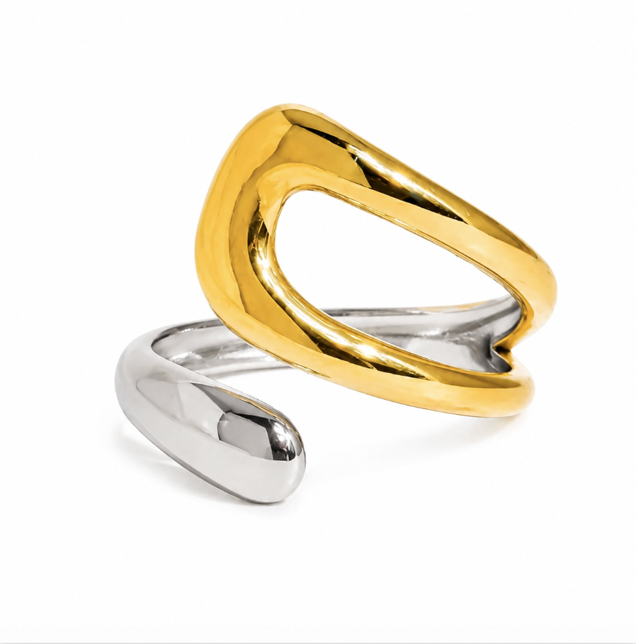 A two-tone abstract open wrap ring featuring a polished gold upper band and a silver lower band, photographed on a clean white background.