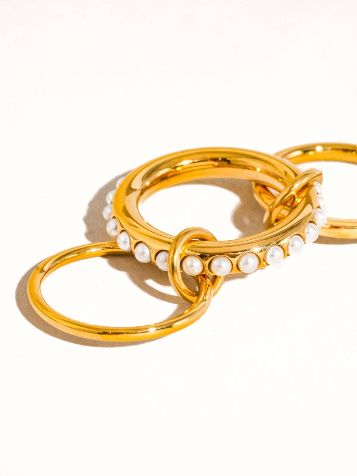 Gold hoop earrings with pearl accents on a white background