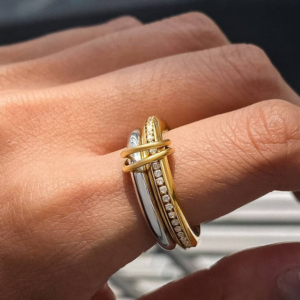 Close-up of a hand wearing a gold ring with a blurred background