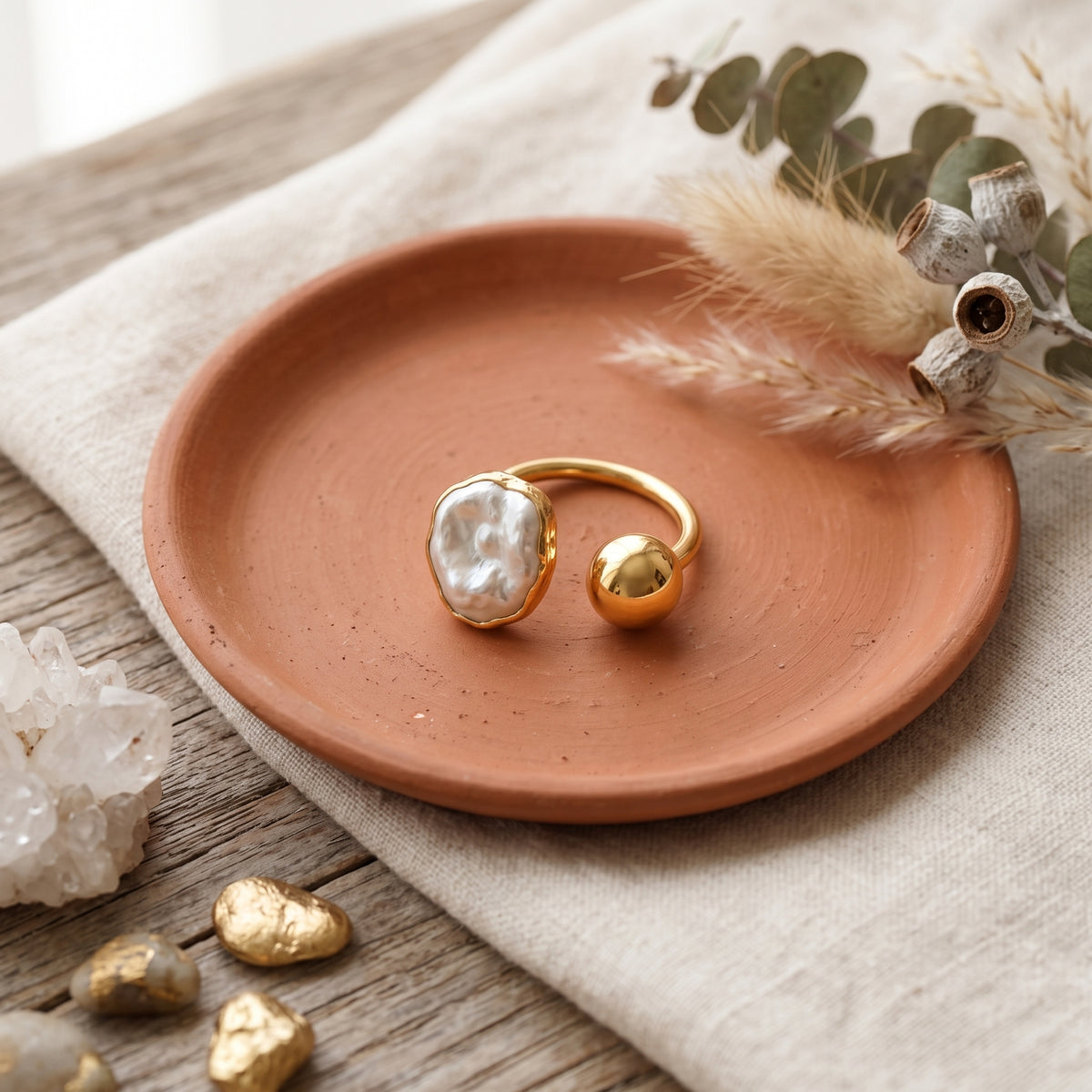 gold and pearl adjustable ring in terra cotta plate